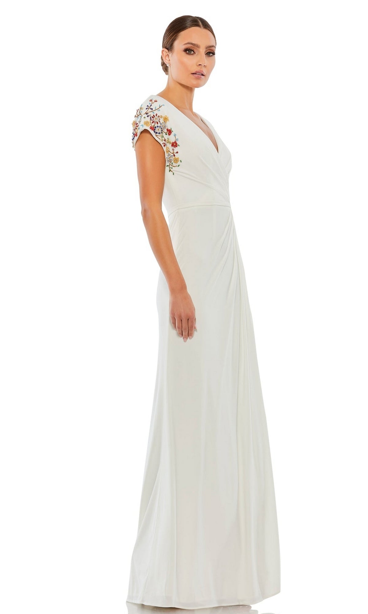 A woman wearing the Mac Duggal 55709 Cap-Sleeve Long Formal Gown with floral shoulder embroidery, standing against a white background.